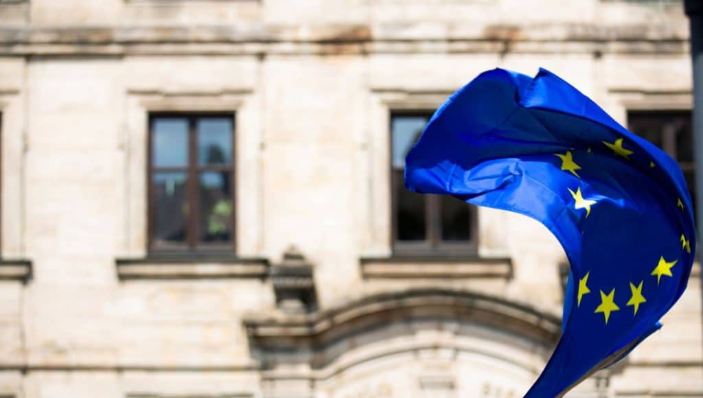 Una bandiera dell'UE sventola davanti a un edificio che rappresenta la Commissione Europea.