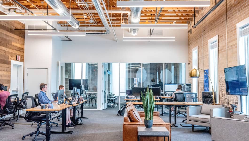 Un open office con le persone sedute alle scrivanie, finanziato dal Microcredito Lazio alle Imprese.