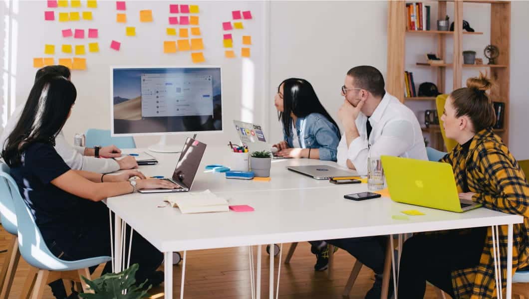 persone attorno a un tavolo con laptop innovacultura regione lombardia